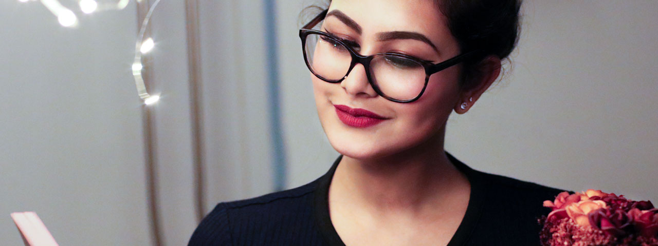 Person wearing glasses reading before an eye doctor's appointment
